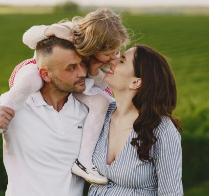 A delightful family moment captured in a lush scenic field, portraying love and happiness.