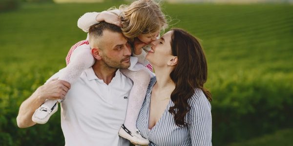 A delightful family moment captured in a lush scenic field, portraying love and happiness.