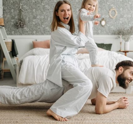 A cheerful family enjoys bonding and playing together on a cozy morning in a stylish bedroom.
