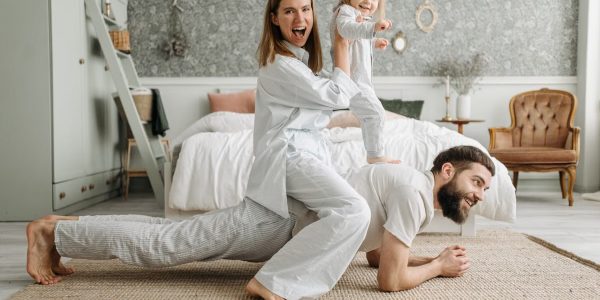 A cheerful family enjoys bonding and playing together on a cozy morning in a stylish bedroom.
